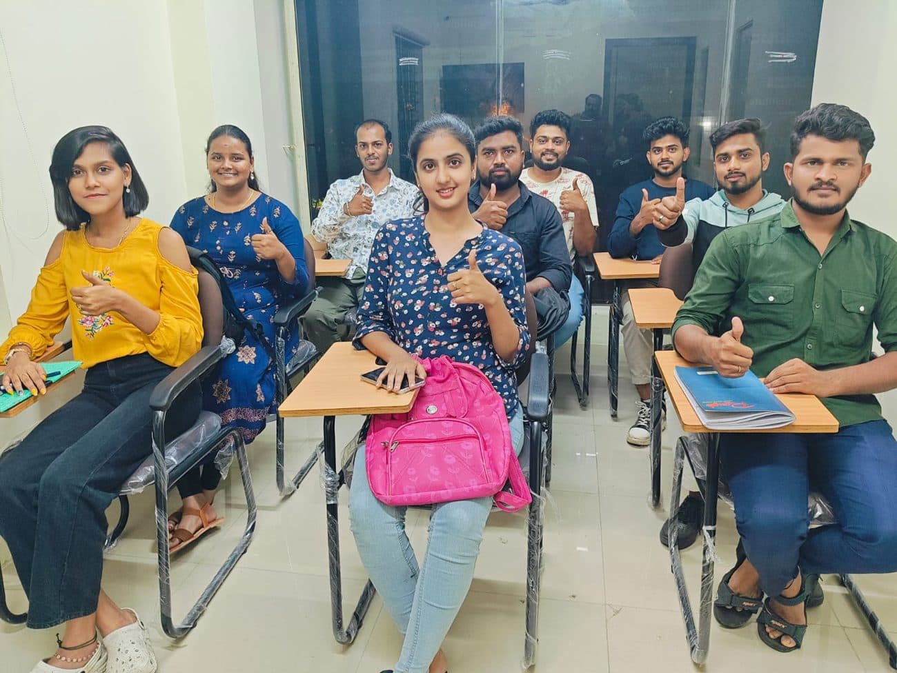 Cadspro students with thumbs up at their classroom desks